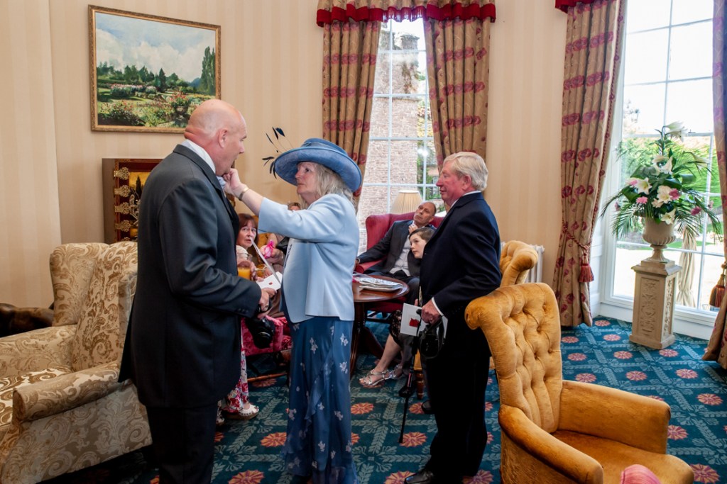 A guests adjust the father-of-the-bride's collar at Shropshire wedding venue, Rowton Castle.