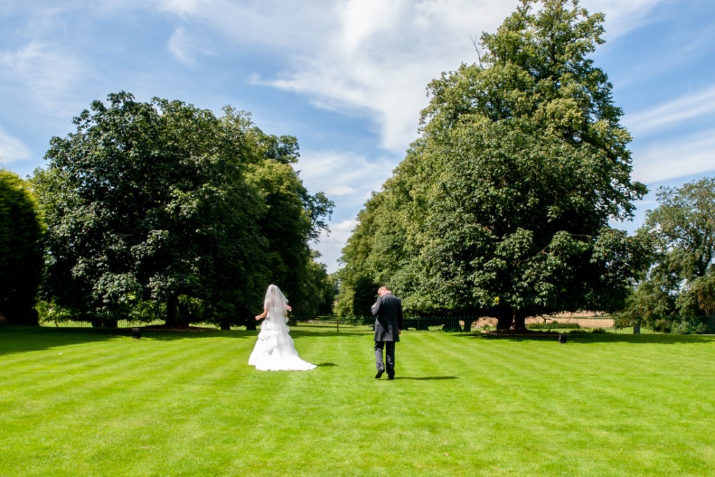 The bride and groom walk through the grounds of Shropshire wedding venue, Rowton Castle.