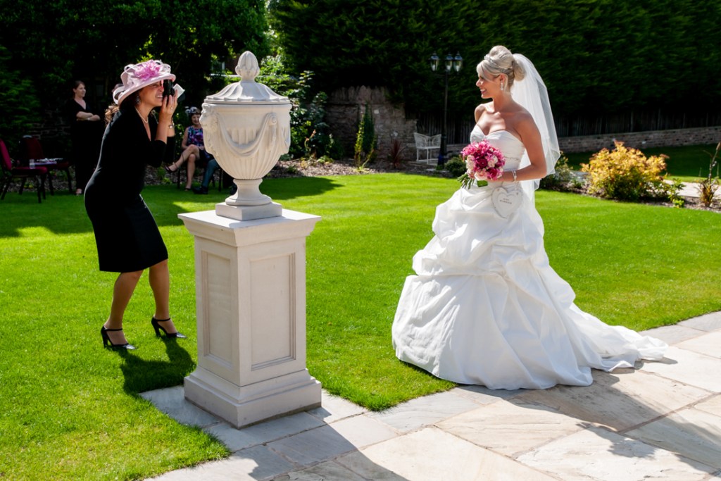 A guest takes a photo of the bride at Shropshire wedding venue, Rowton Castle.