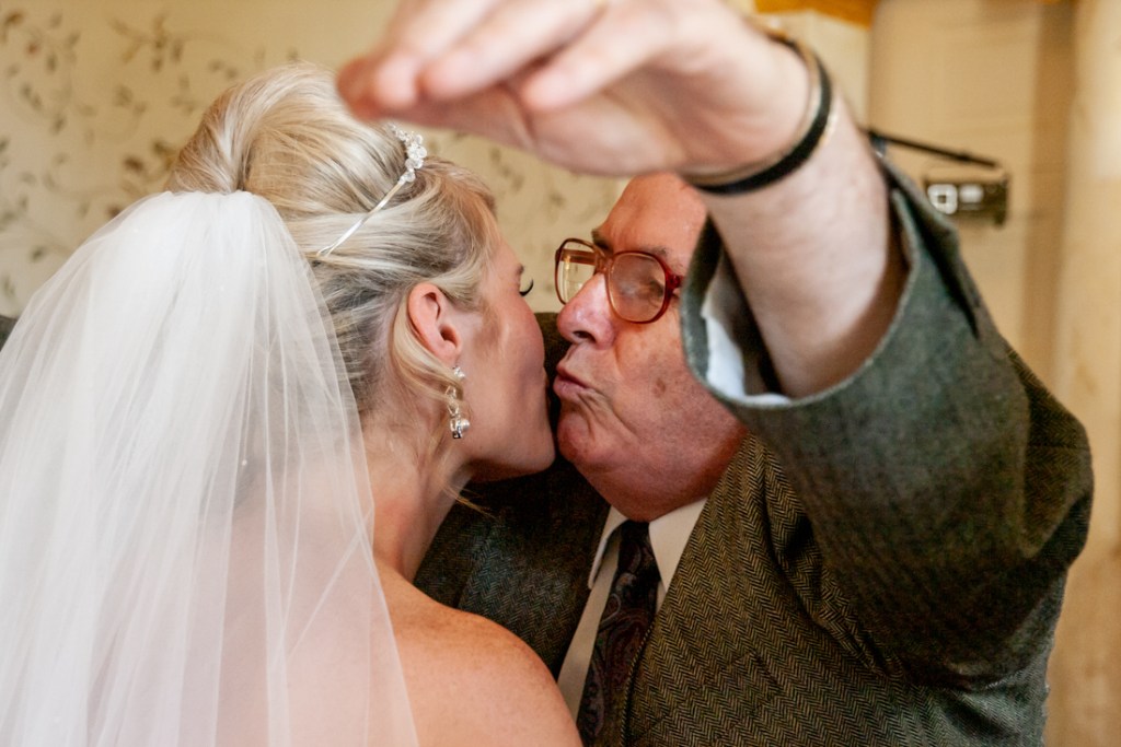 An old male guest kisses the bride at Shropshire wedding venue, Rowton Castle.