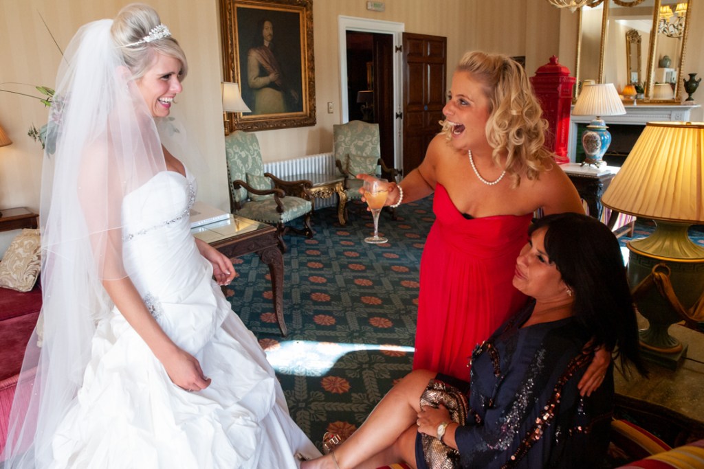 The bride chats with a bridesmaid and guest at Shropshire wedding venue, Rowton Castle.