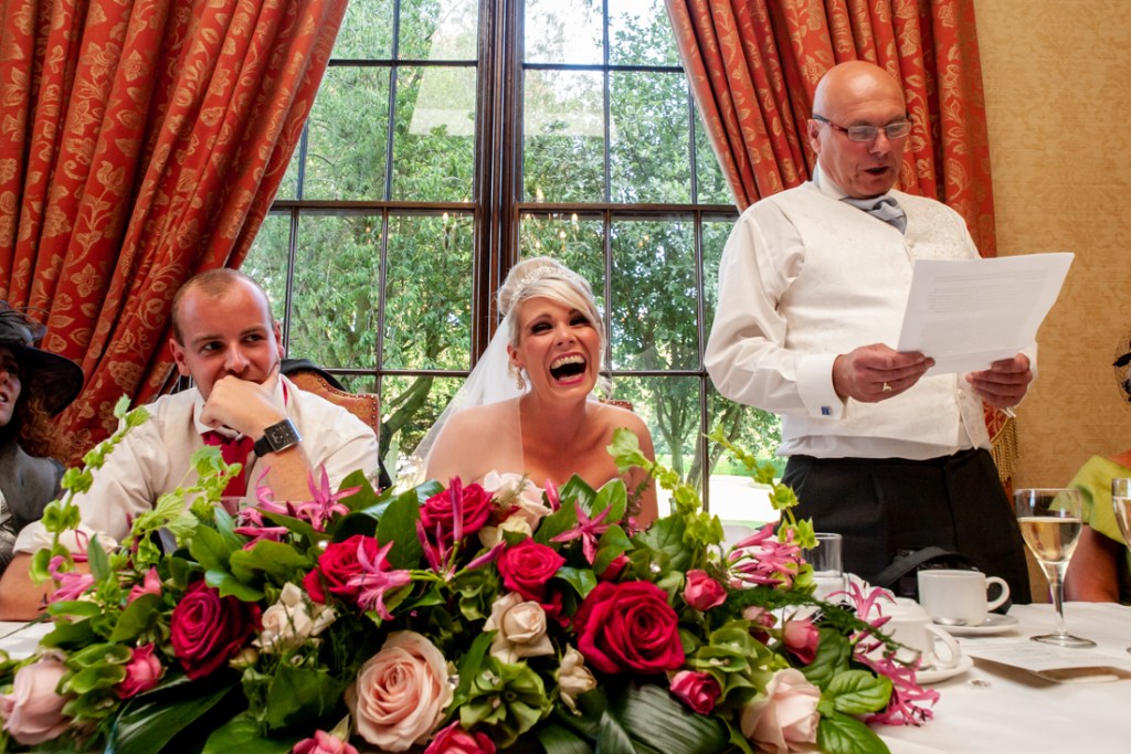 The bride laughs during her father's speech, at Shropshire wedding venue, Rowton Castle.