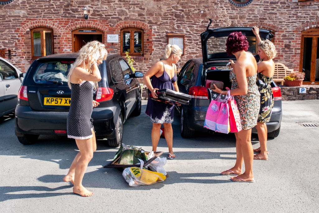 Bridesmaids loading up a car ahead of a wedding at Shropshire wedding venue, Rowton Castle.