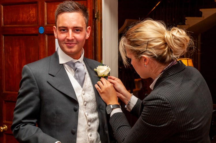 A best man is helped with his buttonhole before a wedding at Rowton Castle in Shropshire.