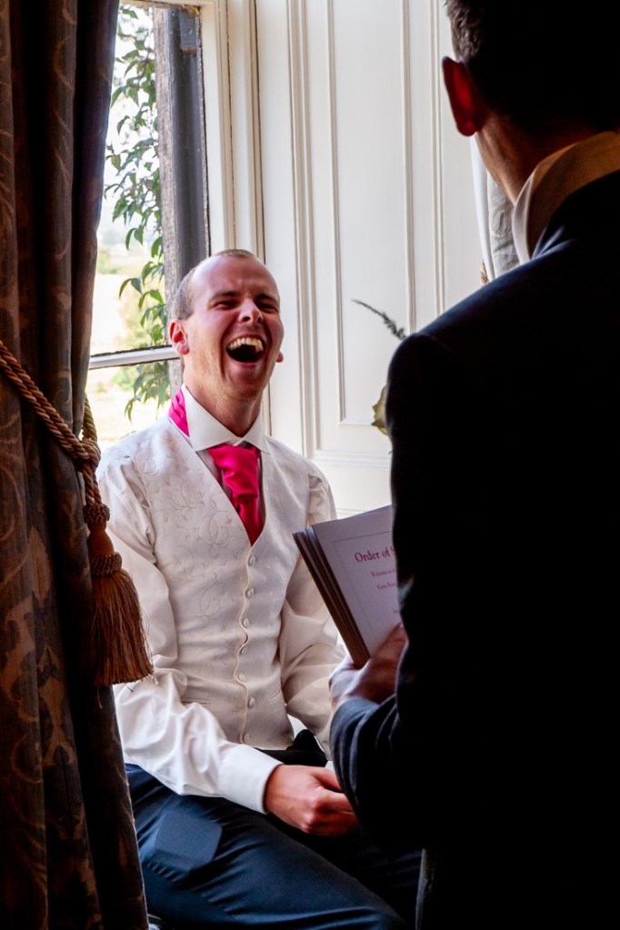 The groom laughs before a wedding at Rowton Castle in Shropshire.