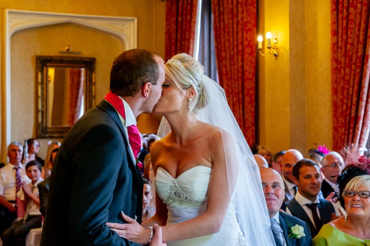 the bride and groom enjoy their first kiss during a wedding at Rowton Castle in Shropshire.