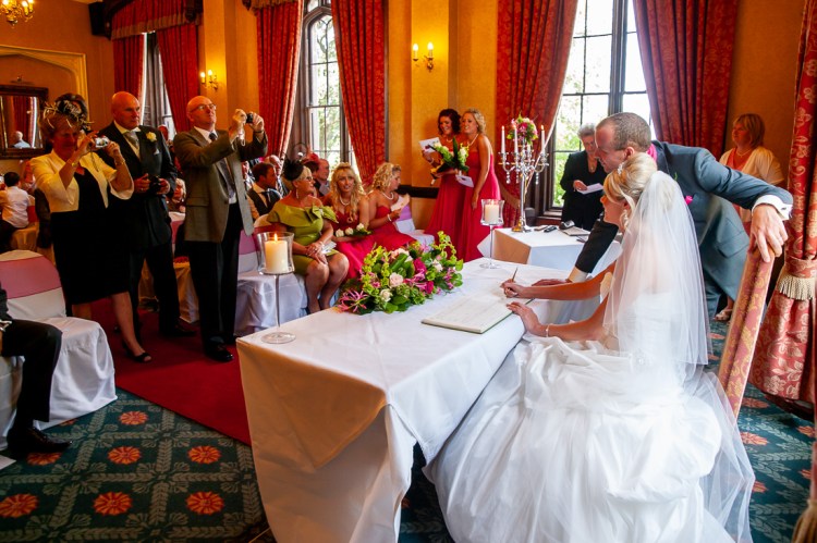 Guests take photos of the bride and groom during a wedding at Rowton Castle in Shropshire.