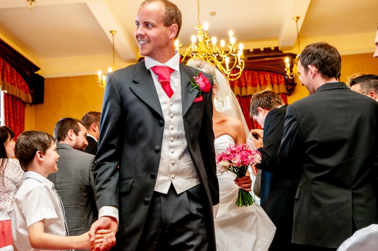 The groom shakes hand with a guest, at the end of the ceremony, during a wedding at Rowton Castle in Shropshire.