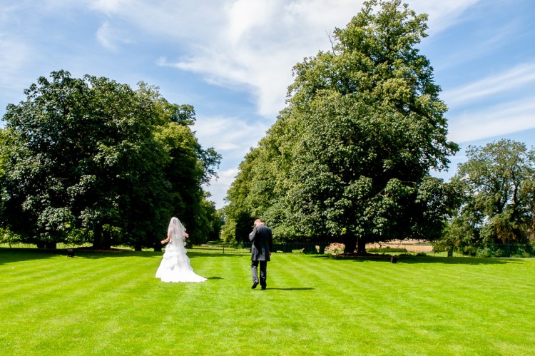 The bride and groom wander through the beautiful grounds, during a wedding at Rowton Castle in Shropshire.