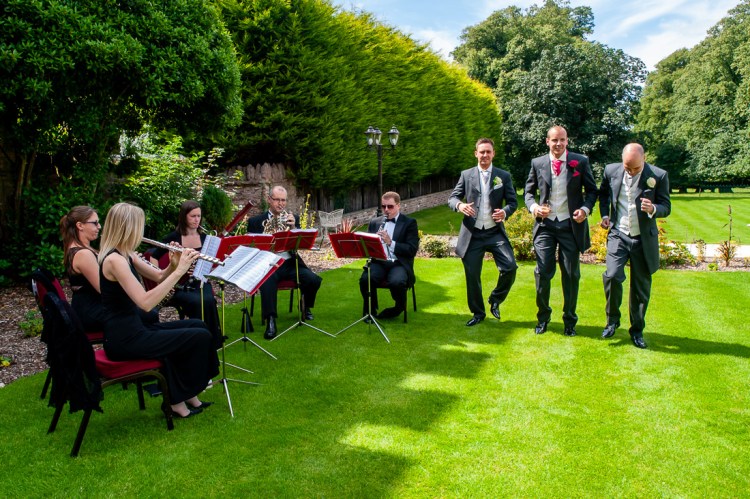 The groomsmen dancing by the lawn quintet, during a wedding at Rowton Castle in Shropshire.