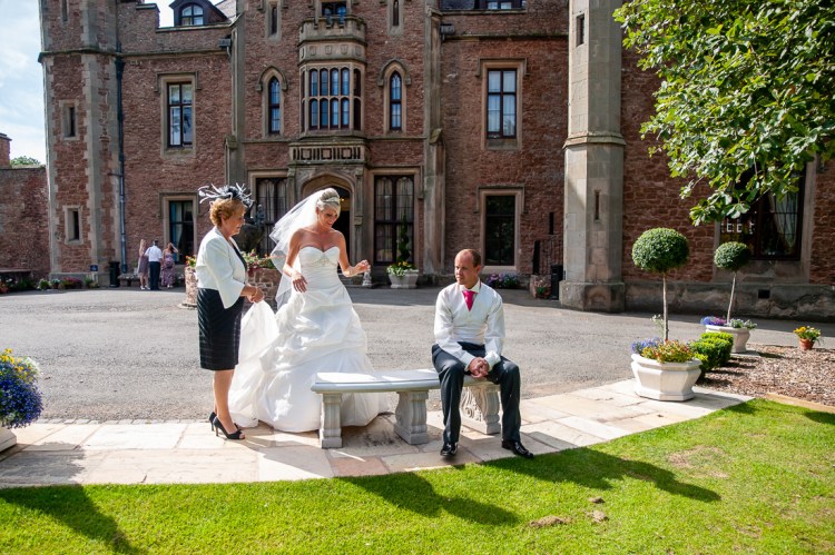 The bride, groom and a guest take a quiet moment during a wedding at Rowton Castle in Shropshire.