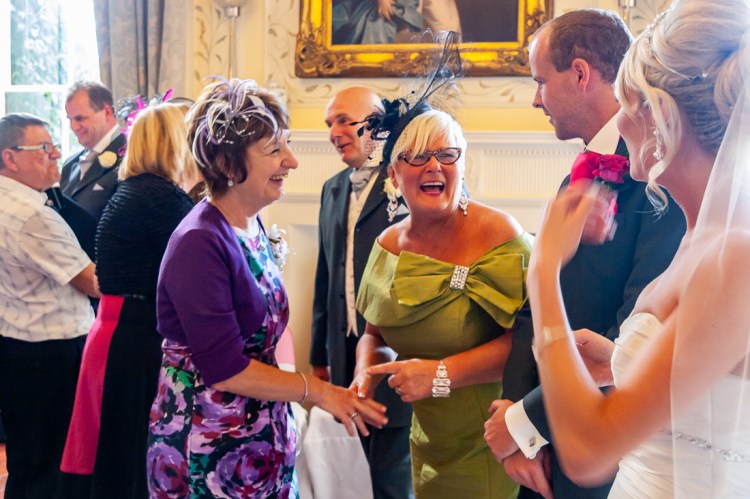 The mother-of-the-bride laughing during the receiving line at a wedding at Rowton Castle in Shropshire.