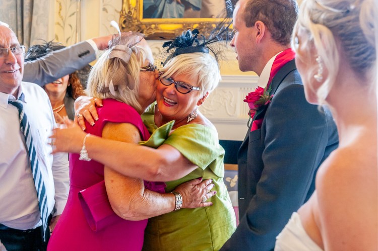 The mother-of-the-bride embraces her sister during the receiving line, at a wedding at Rowton Castle in Shropshire.