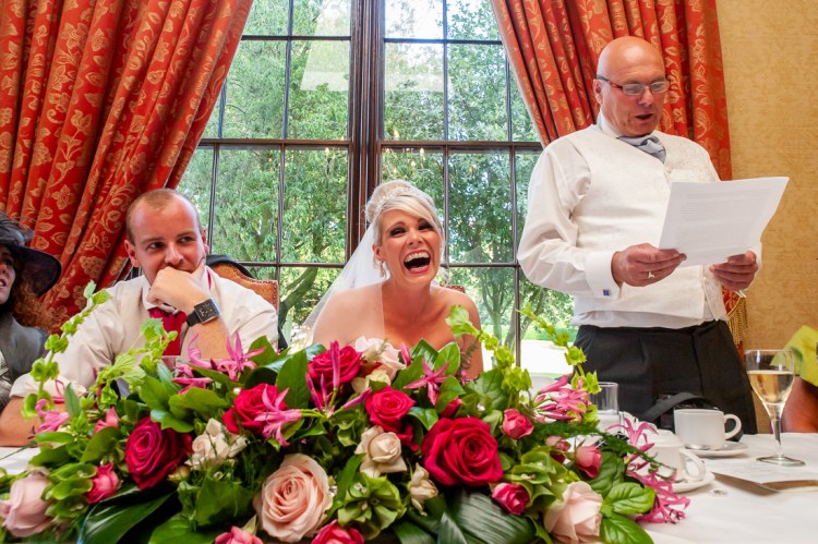The bride laughs during her father's speech, at a wedding at Rowton Castle in Shropshire.