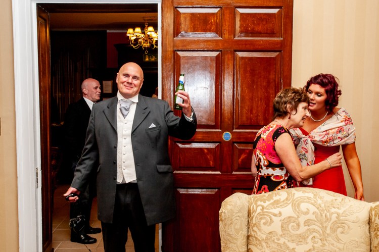 The father-of-the-bride raises a beer bottle during a wedding at Rowton Castle in Shropshire.