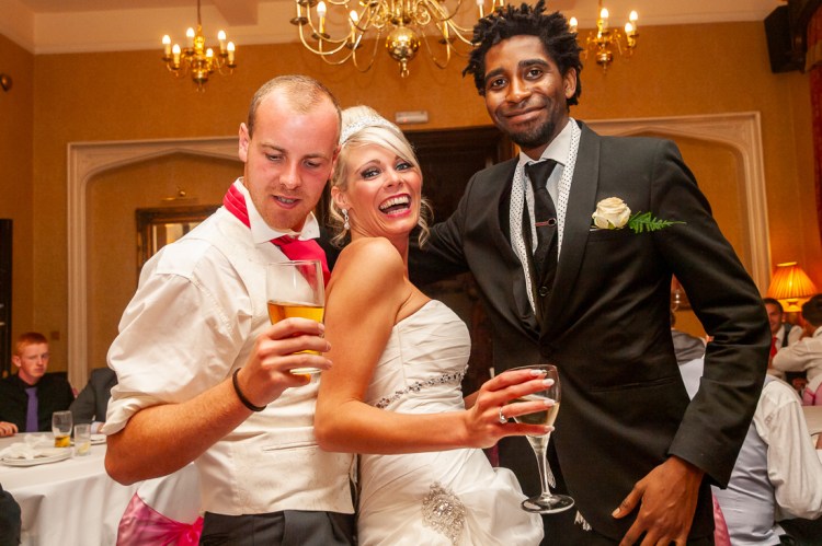 The bride and groom pose with a guest during a wedding at Rowton Castle in Shropshire.