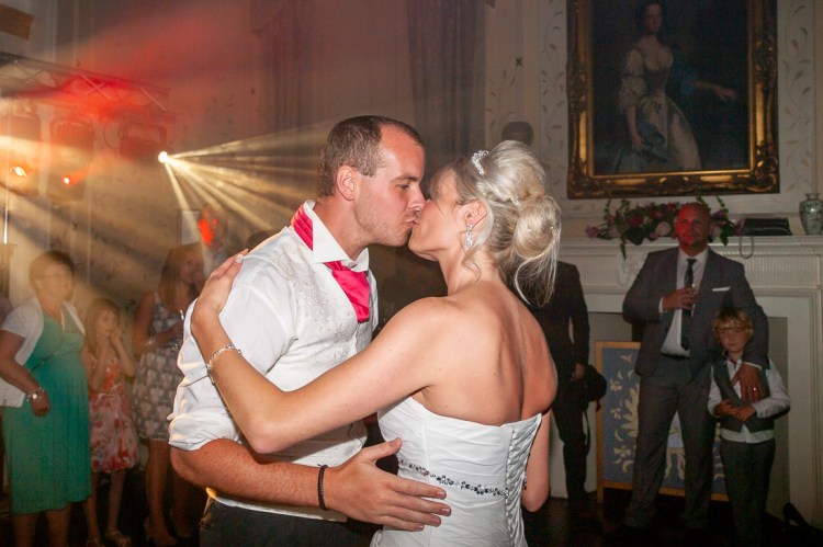 The bride and groom kiss during their first dance, at a wedding at Rowton Castle in Shropshire.