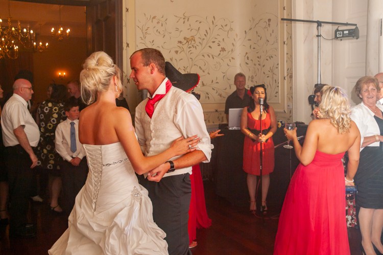 The couple dance in front of the wedding singer at a wedding at Rowton Castle in Shropshire.