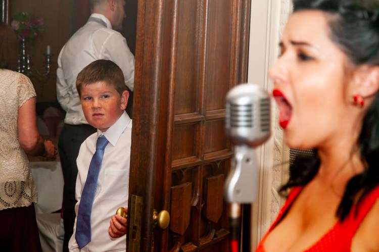 A young guest looks unimpressed by the singer during a wedding at Rowton Castle in Shropshire.