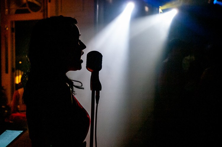 The wedding singer illuminated by spotlights during a wedding at Rowton Castle in Shropshire.