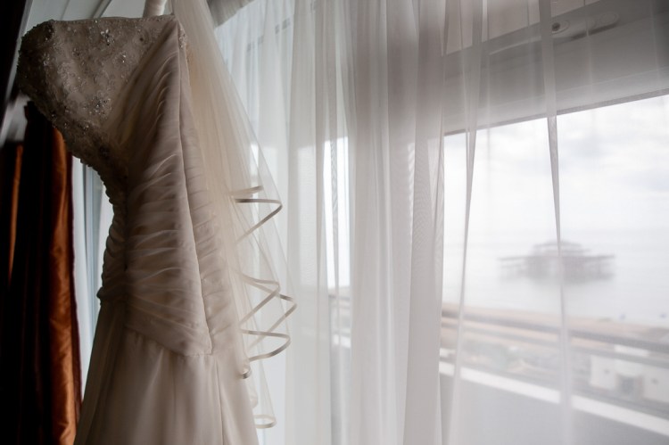 The brides dress hangs in a window, ahead of a wedding at the Holiday Inn Seafront hotel in Brighton, East Sussex.