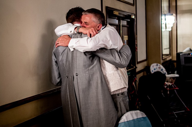 The groom is hugged by his emotional father after the speeches, during a wedding at the Holiday Inn Seafront hotel in Brighton, East Sussex.