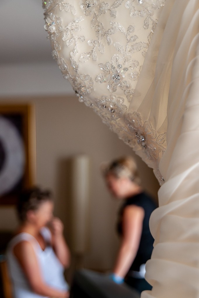 The wedding dress hands, with bridal preps in the background, ahead of a wedding at the Holiday Inn Seafront hotel in Brighton, East Sussex.