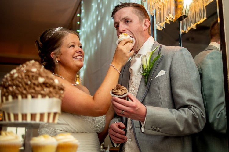 The bride feeds the groom with a cup cake, during a wedding at the Holiday Inn Seafront hotel in Brighton, East Sussex.