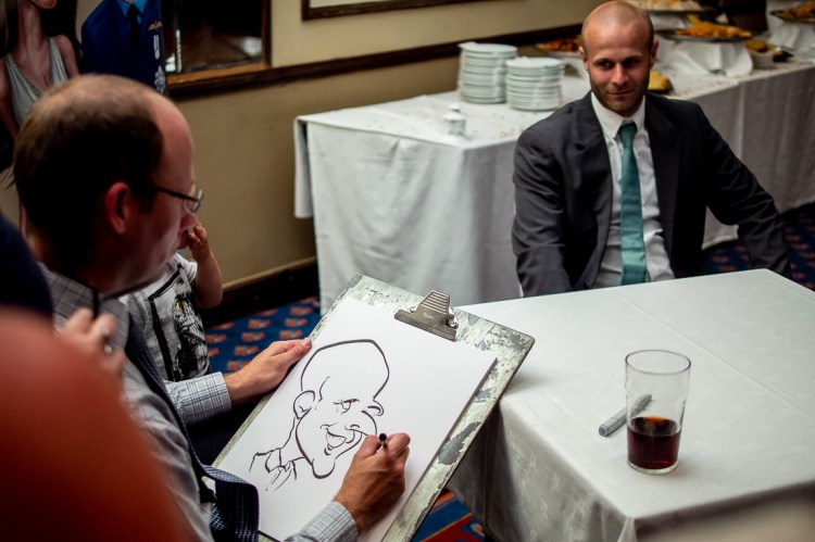 A caricaturist draws a guest, during a wedding at the Holiday Inn Seafront hotel in Brighton, East Sussex.