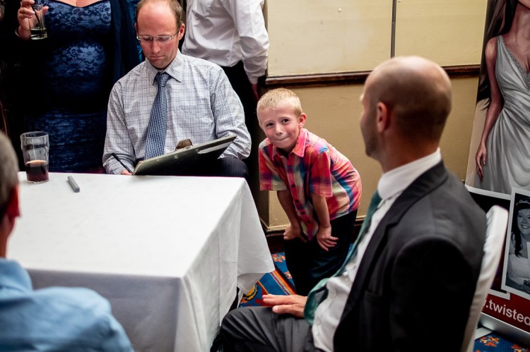A young boy is amused by the caricature of his father, during a wedding at the Holiday Inn Seafront hotel in Brighton, East Sussex.