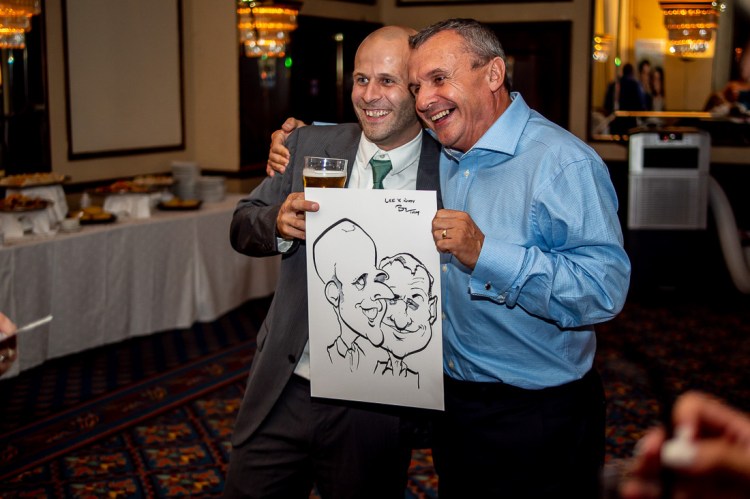 Guest hold up a caricature, during a wedding at the Holiday Inn Seafront hotel in Brighton, East Sussex. 