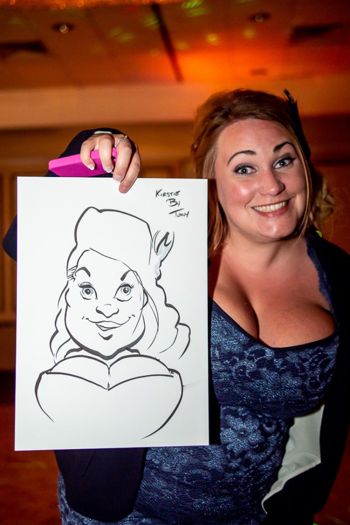 A guest holds up her caricature during a wedding at the Holiday Inn Seafront hotel in Brighton, East Sussex.