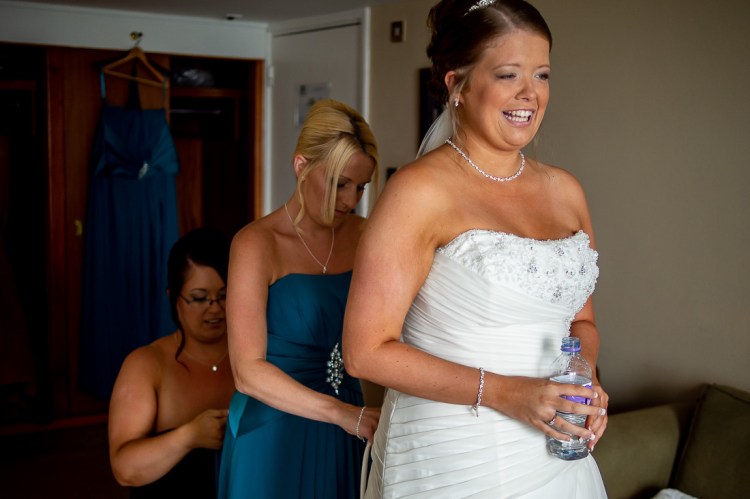 The bride is helped with her dress ahead of a wedding at the Holiday Inn Seafront hotel in Brighton, East Sussex.