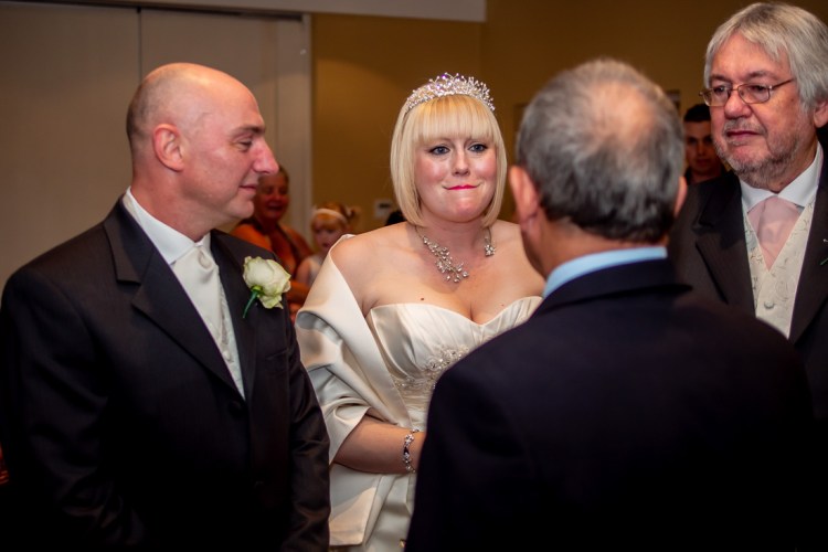 The bride tries to supress a laugh during a wedding ceremony at the Meon Valley Hotel, near Southampton, in Hampshire.