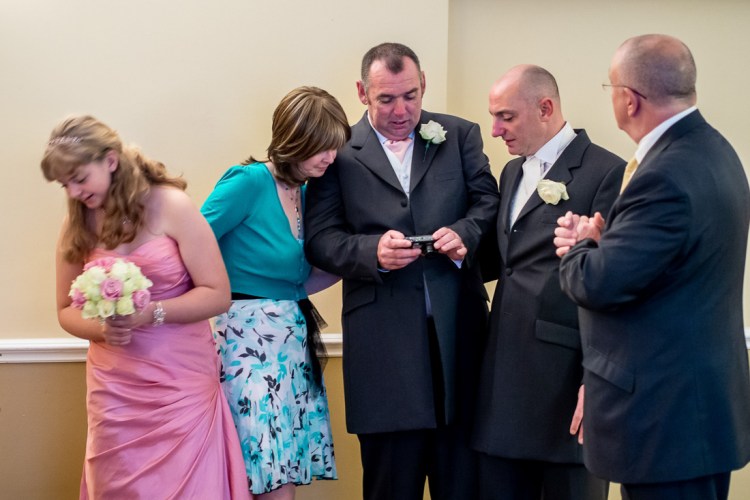 Wedding guests look at a photo during a wedding at the Meon Valley Hotel, near Southampton, in Hampshire.