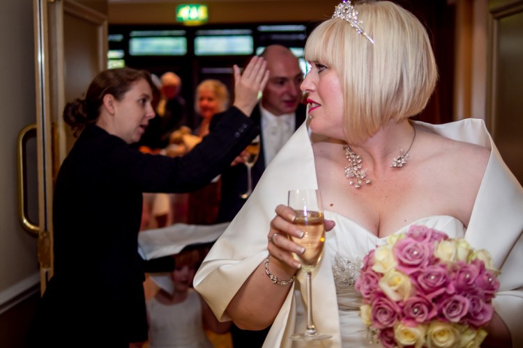 THe bride with a drink after the ceremony at a wedding at the Meon Valley Hotel, near Southampton, in Hampshire.