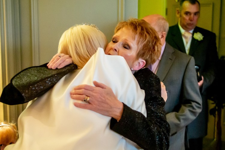 A guest hugs the bride during a wedding at the Meon Valley Hotel, near Southampton, in Hampshire.