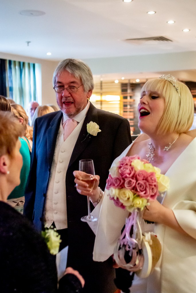The bride laughs with a guest during a wedding at the Meon Valley Hotel, near Southampton, in Hampshire.