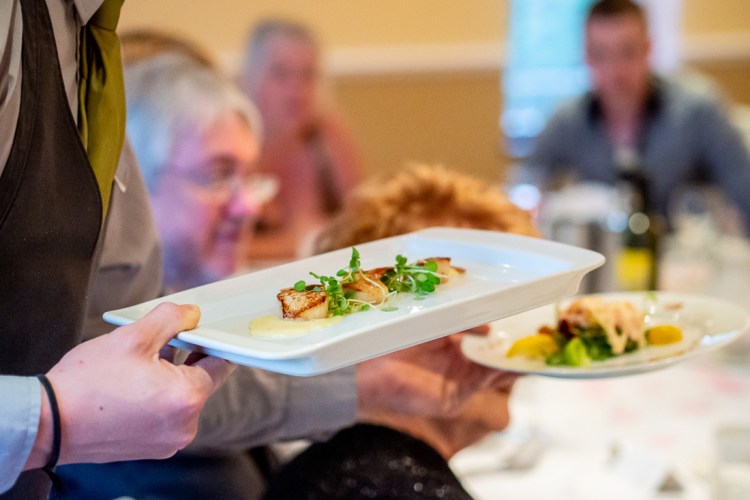 CAtering staff deliver food during a wedding at the Meon Valley Hotel, near Southampton, in Hampshire.
