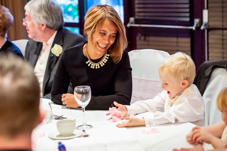 A guest laughs with a young boy during a wedding at the Meon Valley Hotel, near Southampton, in Hampshire.