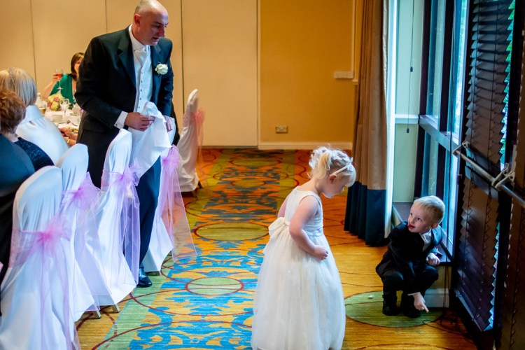 The groom watching his kids play, during a wedding at the Meon Valley Hotel, near Southampton, in Hampshire.