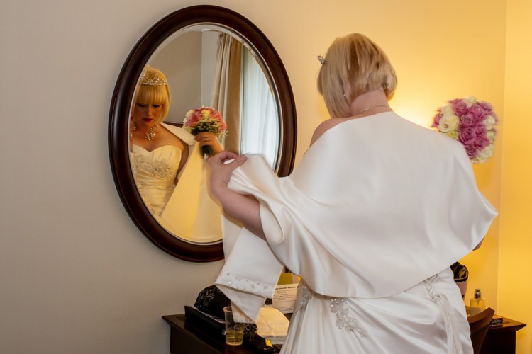 The bride makes a final check of herself before a wedding at the Meon Valley Hotel, near Southampton, in Hampshire.