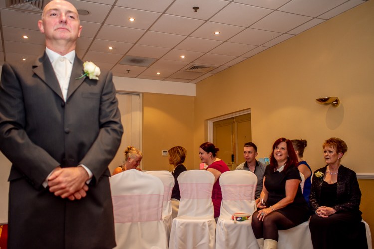 The groom waits patiently at the start of a a wedding ceremony at the Meon Valley Hotel, near Southampton, in Hampshire.