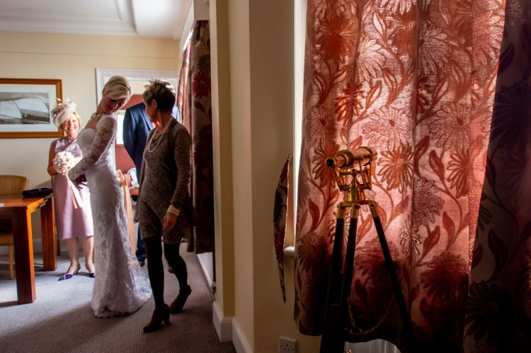 The bride has her dress adjusted, ahead of a wedding at the Old Ship Hotel in Brighton, East Sussex.
