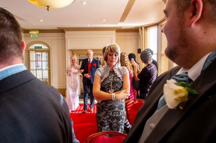 The groom and best man watch as the bride comes up the aisle during the wedding ceremony at the Old Ship Hotel in Brighton, East Sussex.