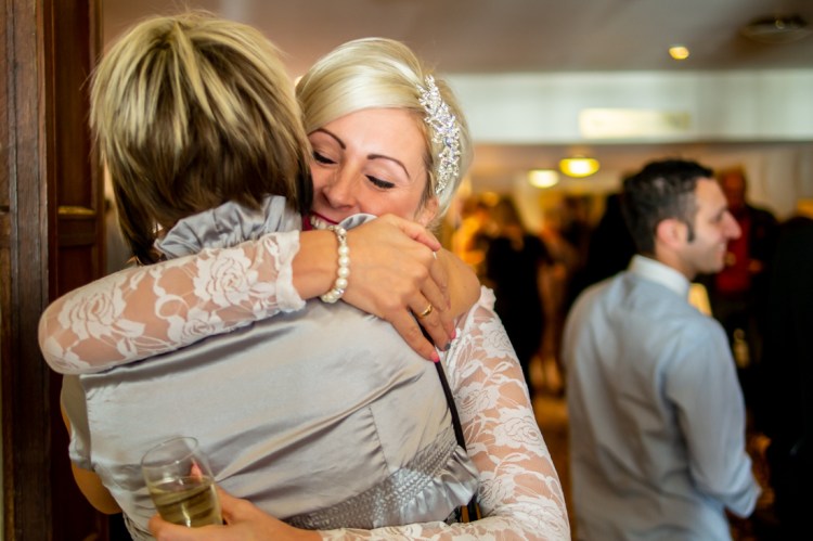 The bride hugs a guest after the wedding ceremony at the Old Ship Hotel in Brighton, East Sussex.