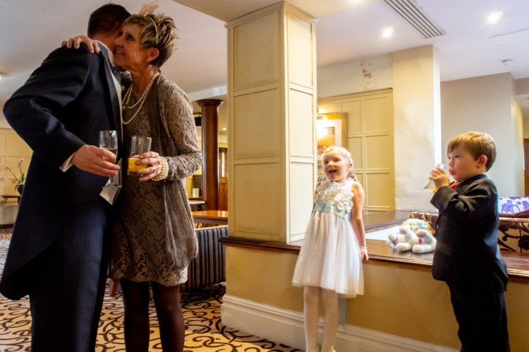 Children look on amused as the mother-of-the-bride kisses the groom, during a wedding at the Old Ship Hotel in Brighton, East Sussex.