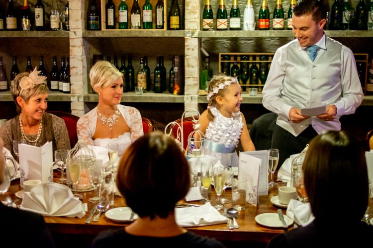 The flower girl tries to read the grooms sppech, during the wedding ceremonyat the Old Ship Hotel in Brighton, East Sussex.