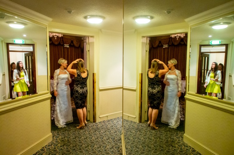 The bride and friends in a double mirror reflection , during the evening wedding reception at the Old Ship Hotel in Brighton, East Sussex.