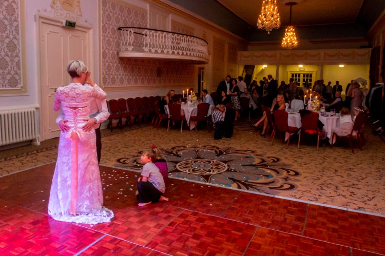 A young guest watches the bride and groom's first dance during the evening wedding reception at the Old Ship Hotel in Brighton, East Sussex.